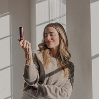 Woman holding a phone in front of a large window