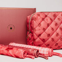 Pink quilted pouch and rolled-up mat on a light gray background
